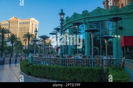 Sitzplätze im Freien im Restaurant Mon Ami Gabi im Paris Las Vegas Hotel and Casino mit Caesars Palace in der Ferne in Las Vegas, Nevada, USA. Stockfoto