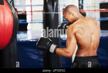 Beim Boxen dreht sich alles um Hingabe und Entschlossenheit. Ein afroamerikanischer Boxer, der mit einem Boxball trainiert Stockfoto