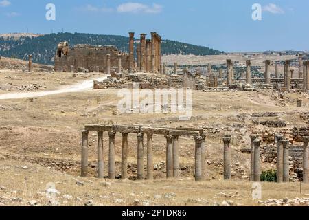 Ein Blick vorbei an einer Steinkolonnade in Richtung Artemistempel an der antiken Stätte Jerash in Jordanien. Stockfoto