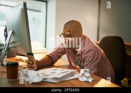 Die späten Nächte haben ihn ein wenig im Delirium gelassen. Ein junger Designer, der lange in einem Büro arbeitet Stockfoto