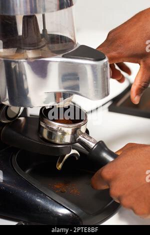 Geröstete Güte. Ein Barista, der gemahlenen Kaffee für die Zubereitung zubereitet Stockfoto