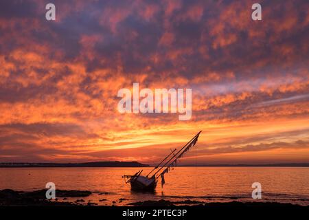 Altes Segelboot, das vor Gorriti Island gestrandet ist, bei Sonnenuntergang Stockfoto