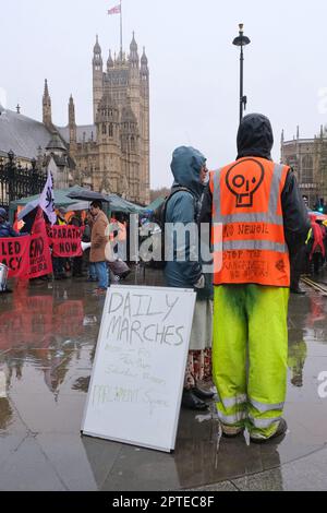 London, Großbritannien. Just Stop Oil-Aktivisten stehen mit einem Brett, auf dem die Zeiten für die nächste geplante Runde langsamer Marschen in der Hauptstadt angezeigt werden. Stockfoto