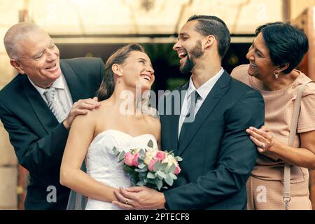 Hochzeit, glücklich und Paar mit den Eltern auf einer Feier der Liebe auf einer Veranstaltung mit Glück. Lächeln, feiern und junge Braut und Bräutigam nach der Ehe Stockfoto