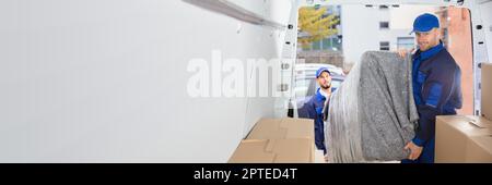 Happy Movers Entladen Möbel Aus Lkw. Mover-Service Stockfoto