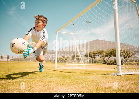 Fußball, Torwart für Jungen und Sprung, um den Ball vor Toren auf dem Sportplatz zu bewahren. Fußball-, Kinder- und Wettkampfspiel mit Fitness, Torhüter und socc Stockfoto