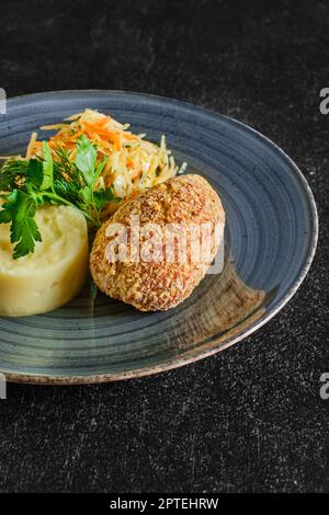 Traditioneller Kiewer Kürbis mit Kartoffelpüree und eingelegtem Kohl Stockfoto