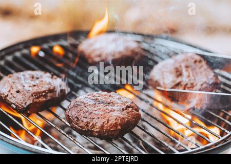 Nahaufnahme Foto eines Grills auf dem Hinterhof. Leckere saftige Patty für Burger. Charcoal Grill Barbecue: Traditionelle Amerikanische Küche. Köstliches Essen für einen Weeken Stockfoto