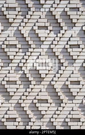 Ein Muster aus weißen Ziegeln in Form von Diamanten. Dekoration der Mauern während der Sowjetunion Stockfoto