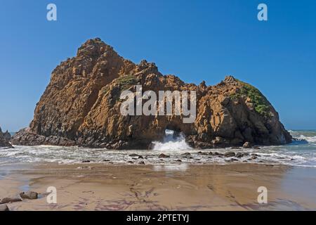 Wasser stürzt durch einen Sea Arch in Pfeiffer Beach in Kalifornien Stockfoto