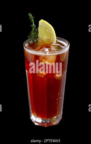 Glas mit dunklem Brot Kwass, Eiswürfel und Zitronenscheibe auf schwarzem Hintergrund Stockfoto