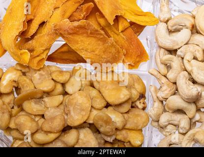 Geröstete und gesalzene Fava-Bohnen, Cashewnüsse und getrocknete Mangoscheiben für einen gesunden veganen und vegetarischen Ernährungs-Snack. Hoch in Protein, Vitamine, Diät-Fi Stockfoto