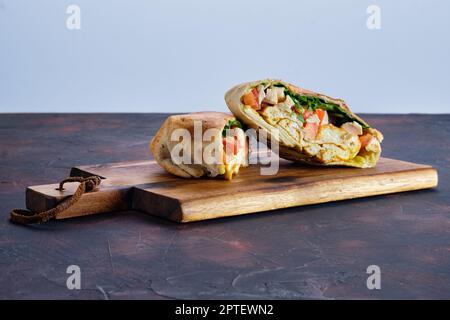 Fladenbrot gefüllt mit Hähnchen, Tomaten und Omelette Stockfoto