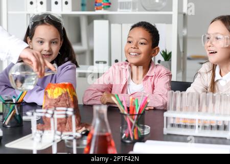 Kleine Kinder experimentieren mit Lehrer und chemischem Vulkan im Wissenschaftsunterricht Stockfoto