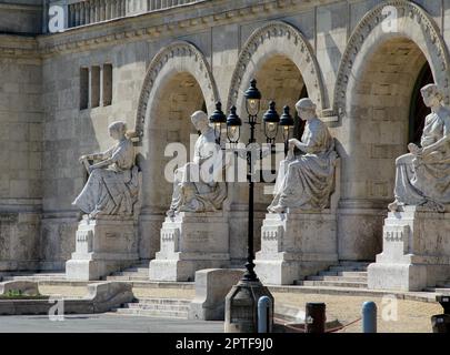 Drei Bogeneingänge mit Statuen und einer dekorativen Straßenlampe. Hochwertiges Foto Stockfoto