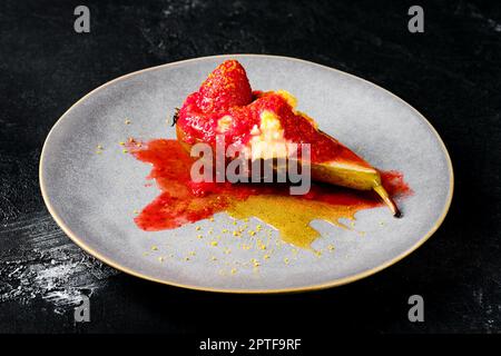 Teller mit süß gebackenen Birnen mit Mascarpone, Karamellsirup und Erdbeermarmelade Stockfoto