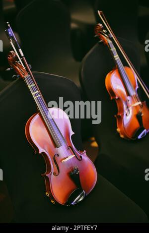 Detailansicht von zwei Violinen auf einigen Stühlen. Stockfoto