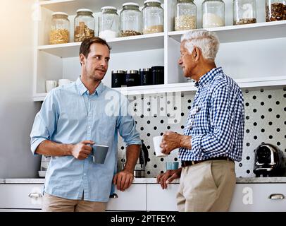 Er kann immer seinen Vater um Rat fragen. Ein Mann und sein älterer Vater trinken zu Hause Kaffee. Stockfoto
