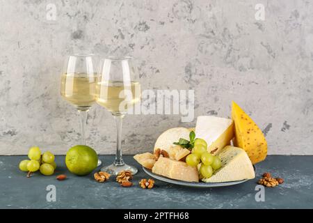 Verschiedene Käsesorten, Obst und Gläser mit Wein auf dem Tisch Stockfoto