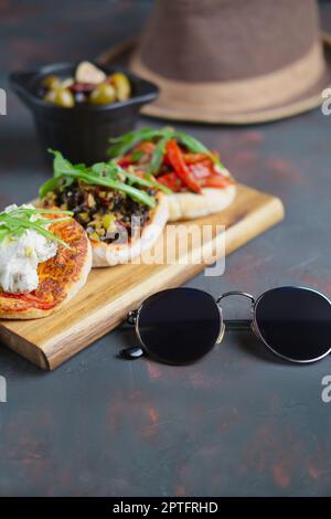 Köstliche Tapas. Kleine Sandwiches mit Ziegenkäse, gehackten Oliven und Nüssen, cured Tomaten und gebratener Paprika. Stockfoto