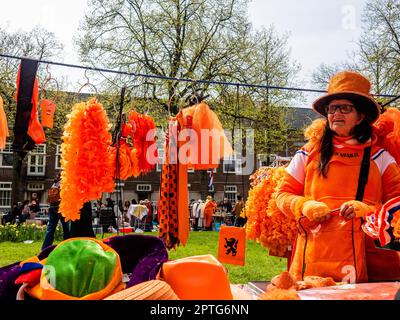 Amsterdam, Niederlande. 27. April 2023. Eine Frau wird gesehen, wie sie alle möglichen orangefarbenen Kleidungsstücke und Komplemente verkauft. Der Königstag ist bekannt für eines der größten und farbenprächtigsten Feste des Landes, insbesondere in Amsterdam. Die Stadt ist voller Orange, während die Menschen die größte Straßenparty des Jahres genießen, die freien Märkte genießen und Spaß auf den Booten entlang der Kanäle haben. Kredit: SOPA Images Limited/Alamy Live News Stockfoto
