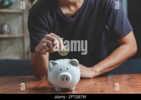 Investment Crypto Bitcoin Blockchain Finance Banking Wirtschaft Börse Handel Börse und Geld sparen Mann hält Münze Putting Sparschwein Geschäft Stockfoto