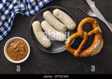 Traditionelle bayerische Weißwürste auf dem Teller und Brezen. Draufsicht. Stockfoto