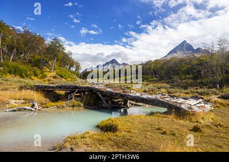 Alte, Verfallene Holzbrücke Über Den Glacial Meltwater Creek. Berühmter Wanderweg Laguna Esmeralda. Patagonien Gebirgslandschaft, Tierra Del Fuego Stockfoto