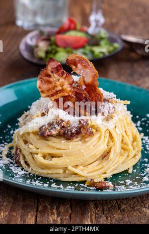Spaghetti Carbonara mit Salat auf Holz Stockfoto