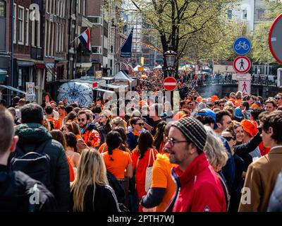 Amsterdam, Niederlande. 27. April 2023. Tausende von Menschen, die orangefarbene Kleidung tragen, werden auf den Straßen gesehen. Der Königstag ist bekannt für eines der größten und farbenprächtigsten Feste des Landes, insbesondere in Amsterdam. Die Stadt ist voller Orange, während die Menschen die größte Straßenparty des Jahres genießen, die freien Märkte genießen und Spaß auf den Booten entlang der Kanäle haben. (Foto: Ana Fernandez/SOPA Images/Sipa USA) Guthaben: SIPA USA/Alamy Live News Stockfoto
