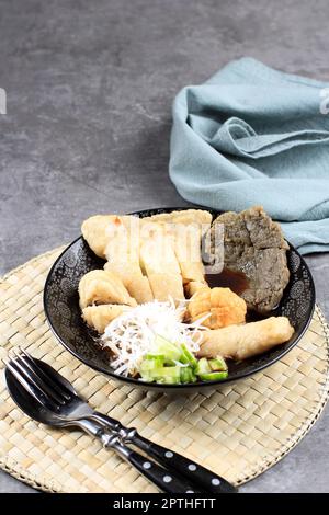 Pempek Palembang oder Empek Empek, traditionelle Küche aus Südsumatra, Indonesien. Pempek aus Mehl und Fisch, serviert mit Cuko und Gurke. Stockfoto