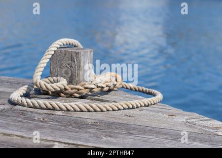 Eine Anlegestelle um einen Poller auf einem hölzernen Pier Stockfoto