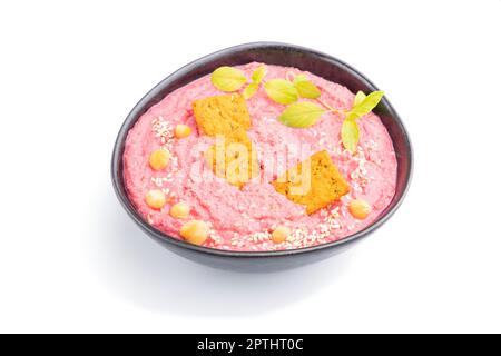 Hummus mit Rüben und mikrogrünen Basilikum Sprossen in Keramikschale isoliert auf weißem Hintergrund. Seitenansicht, Nahaufnahme. Stockfoto