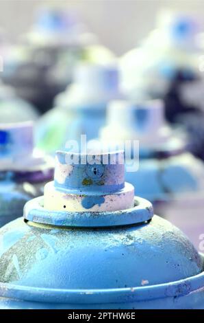 Eine Menge schmutzige und Aerosoldosen mit hellen blauen Farbe. Makro Foto mit geringer Tiefenschärfe. Selektiver Fokus auf der Spritzdüse Stockfoto