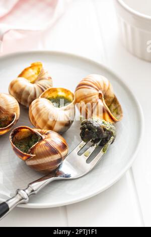 Schnecken mit Petersilienbutter, Bourgogne Escargot Schnecken auf dem Teller. Delikatesisches Essen. Stockfoto