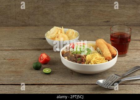 Soto Mie Bogor, indonesische traditionelle Rindfleisch-Nudelsuppe mit Rindfleisch, Frühlingsrolle, Kohl und Tomaten. Bereich für Text kopieren Stockfoto