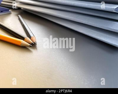 Drei Bleistifte liegen scharf gespitzt neben Ordnern mit Blättern und Dokumenten auf dem Büroschreibtisch im Büro. Briefpapier. Stockfoto