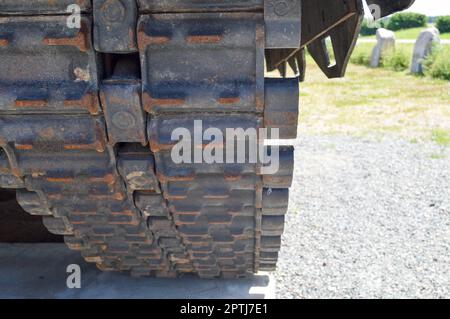 Rostige, schmutzige Metallraupen, schwere Raupe eines großen grünen Militärs, gepanzert, tödliche russische syrische Kampfpanzer und Boden. Stockfoto