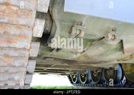 Rostige, schmutzige Metallraupen, schwere Raupe eines großen grünen Militärs, gepanzert, tödliche russische syrische Kampfpanzer und Boden. Stockfoto