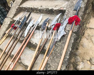 Die alten mittelalterlichen kalten Waffen, Äxte, Halberden, Messer, Schwerter mit Holzgriffen lecken auf den Steintreppen des Schlosses. Stockfoto