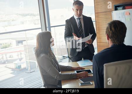 Bewertung des Status des Unternehmens als Team. Ein Team von Profis, das eine Besprechung in einem Sitzungssaal abhält. Stockfoto