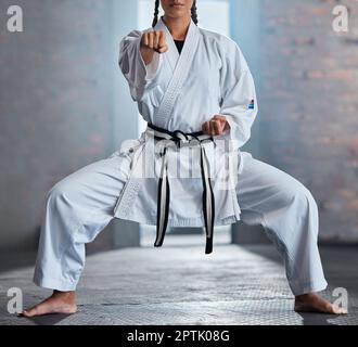 Karate, Sport und Fitness mit einer Kämpferin oder einer Sportlerin, die in einem Fitnessstudio trainiert, während sie ihre gi-Uniform trägt. Gesundheit, Sport und Workout mit einer weiblichen mar Stockfoto