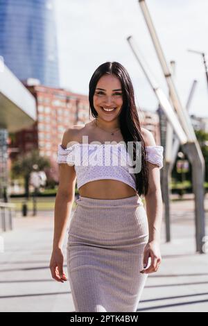Lächelnde Latina Beauty: Ein zwangloses und modernes Straßenporträt an einem sonnigen Tag Stockfoto