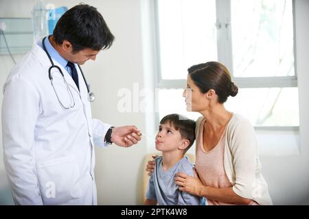 Es wird alles gut. Der Hausarzt nimmt eine kleine Jungen-Auszeit, während seine Mutter ihn hält Stockfoto