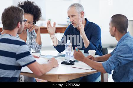 Ich komme in die miese Sache des Projekts. Eine Gruppe von Designern bei der Arbeit in einem Büro Stockfoto