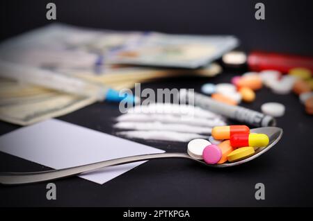 Arzneimittelspritze und Pillen auf dem Löffel Stockfoto