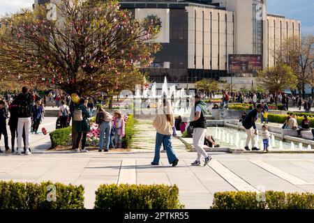 Menschen genießen das schöne Wetter an den Brunnen des berühmten Gebäudes des Nationalen Kulturpalastes oder NDK in Sofia, Bulgarien, Osteuropa Stockfoto