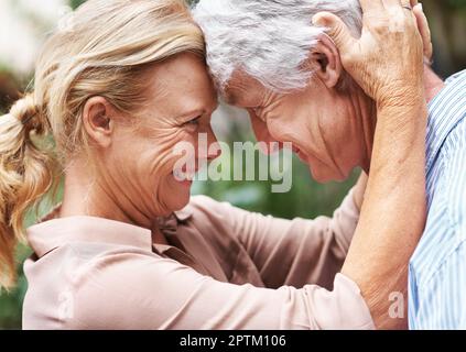 Den Funken am Leben erhalten. Ein älteres Ehepaar, das mit den Köpfen zusammensteht Stockfoto