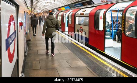 London, Vereinigtes Königreich - 02. Februar 2019: Victoria Line U-Bahn wartet am Bahnhof Vauxhall, Tür offen - Passagiere, die auf dem Bahnsteig gehen Stockfoto