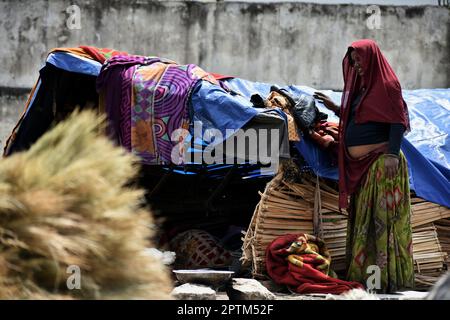 Srinagar, Indien, 27/04/2023, die Sommerhauptstadt des von Indien verwalteten Kaschmir, eine schwangere Migrantin aus dem indischen Staat Rajasthan ruht am 27. April 202 in der Nähe der Besen am Straßenrand. In den letzten drei Jahrzehnten hat Kaschmir einen beispiellosen Zustrom von einkommensschwachen Migranten aus verschiedenen Regionen Indiens erlebt. Viele von ihnen tragen immer noch das Stigma der Unberührbarkeit und der geringen Kastendegradation und leben in Armut mit eingeschränktem Zugang zu Bildung und sanitären Lebensbedingungen. Familien als Ganzes, oft aus dem indischen Staat Rajasthan, arbeiten an handgefertigten Besen aus Ba Stockfoto